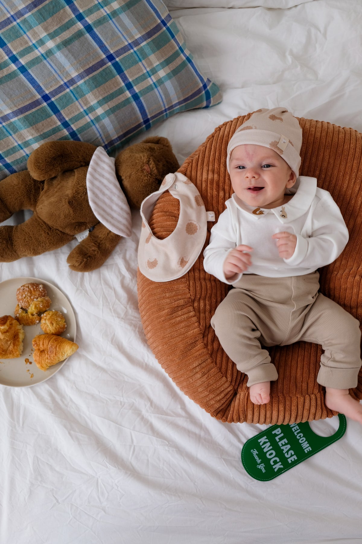 bébé avec bonnet et bavoir cookie sur nid cannelle