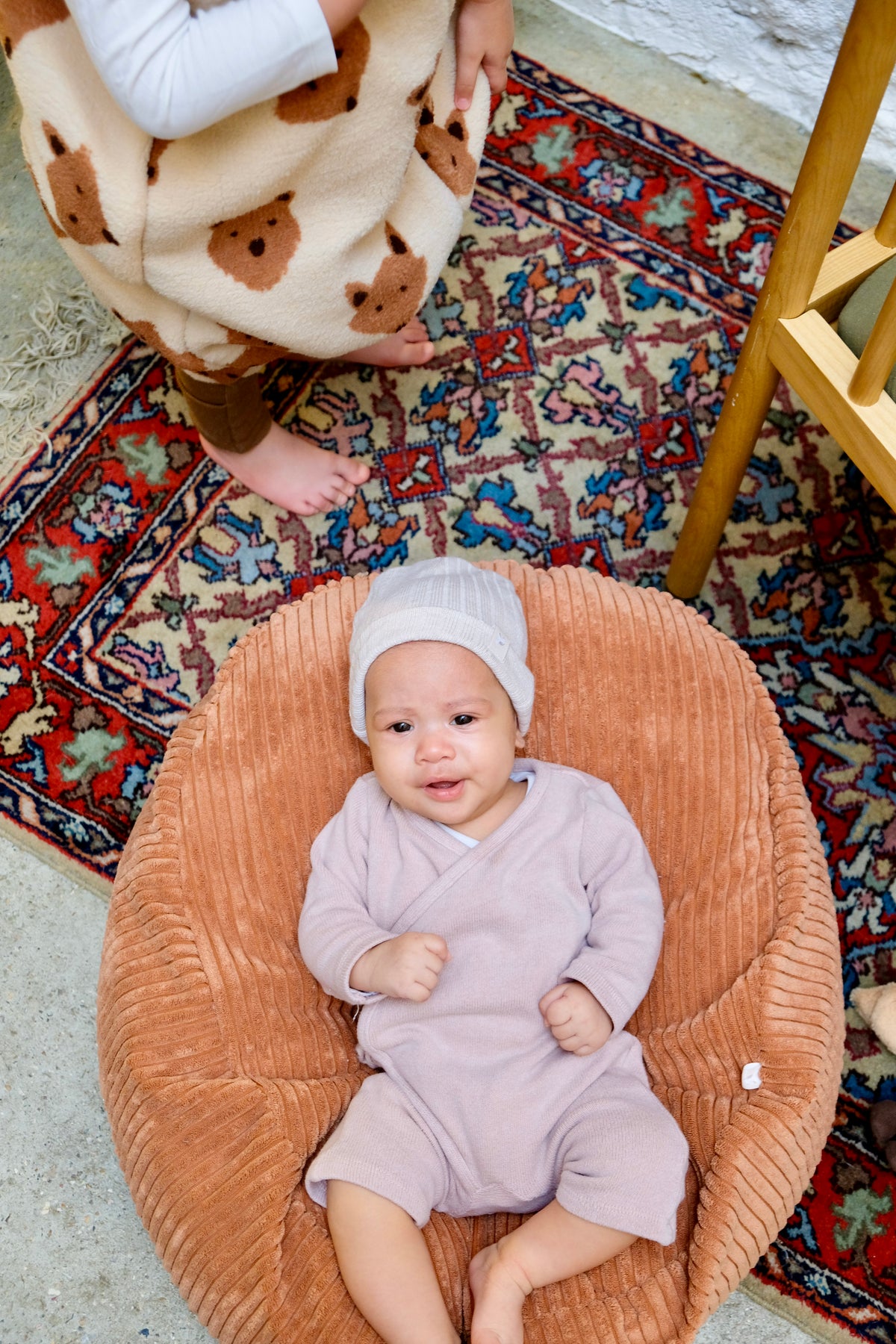 bébé sur nid cannelle avec bonnet de naissance