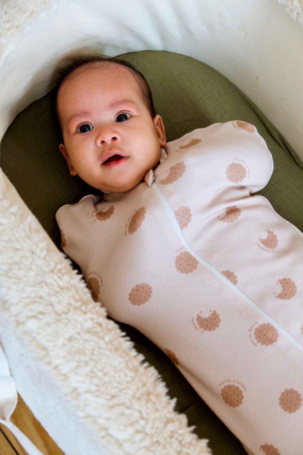 bébé emmailloté se réveillant dans son couffin