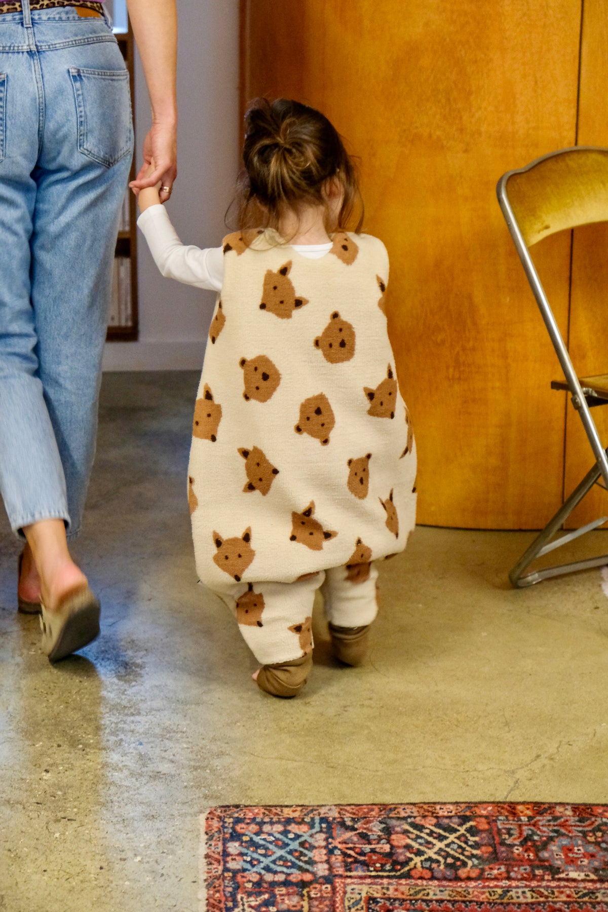 gigoteuses à pieds oursons et renards sur enfant de dos tenant la main de sa maman