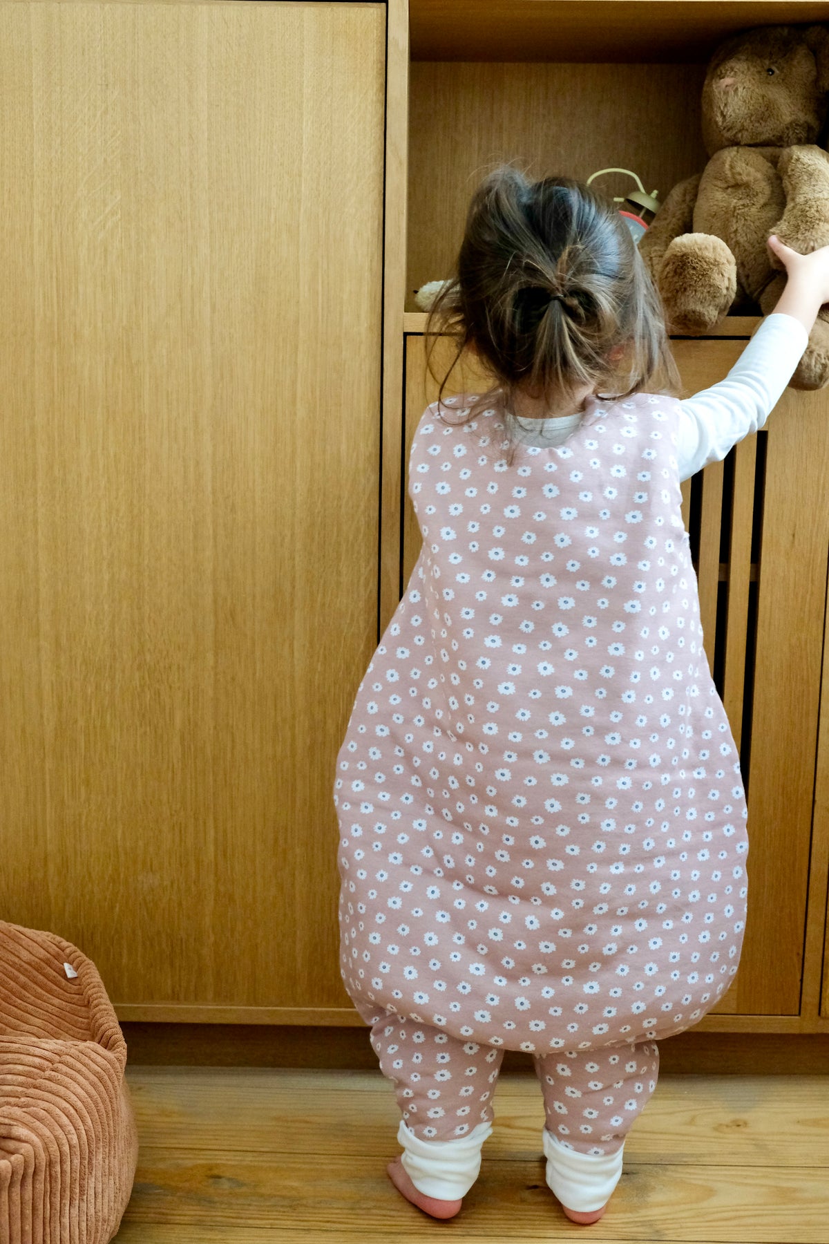 enfant de dos attrapant sa peluche en gigoteuse à pieds guimauve