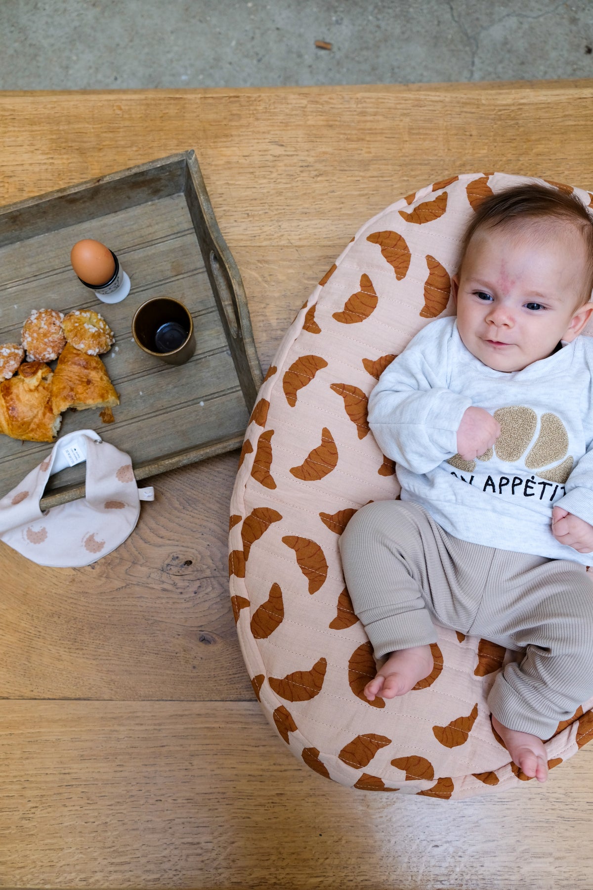 bébé sur nid bag croissant avec plateau petit déj
