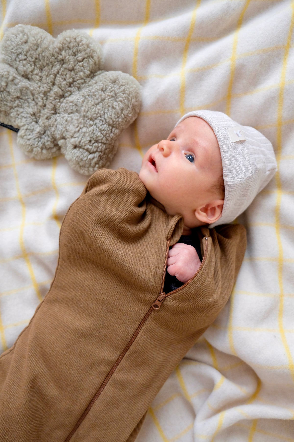 bébé se réveillant avec bonnet latte et emmailloteuse noisette