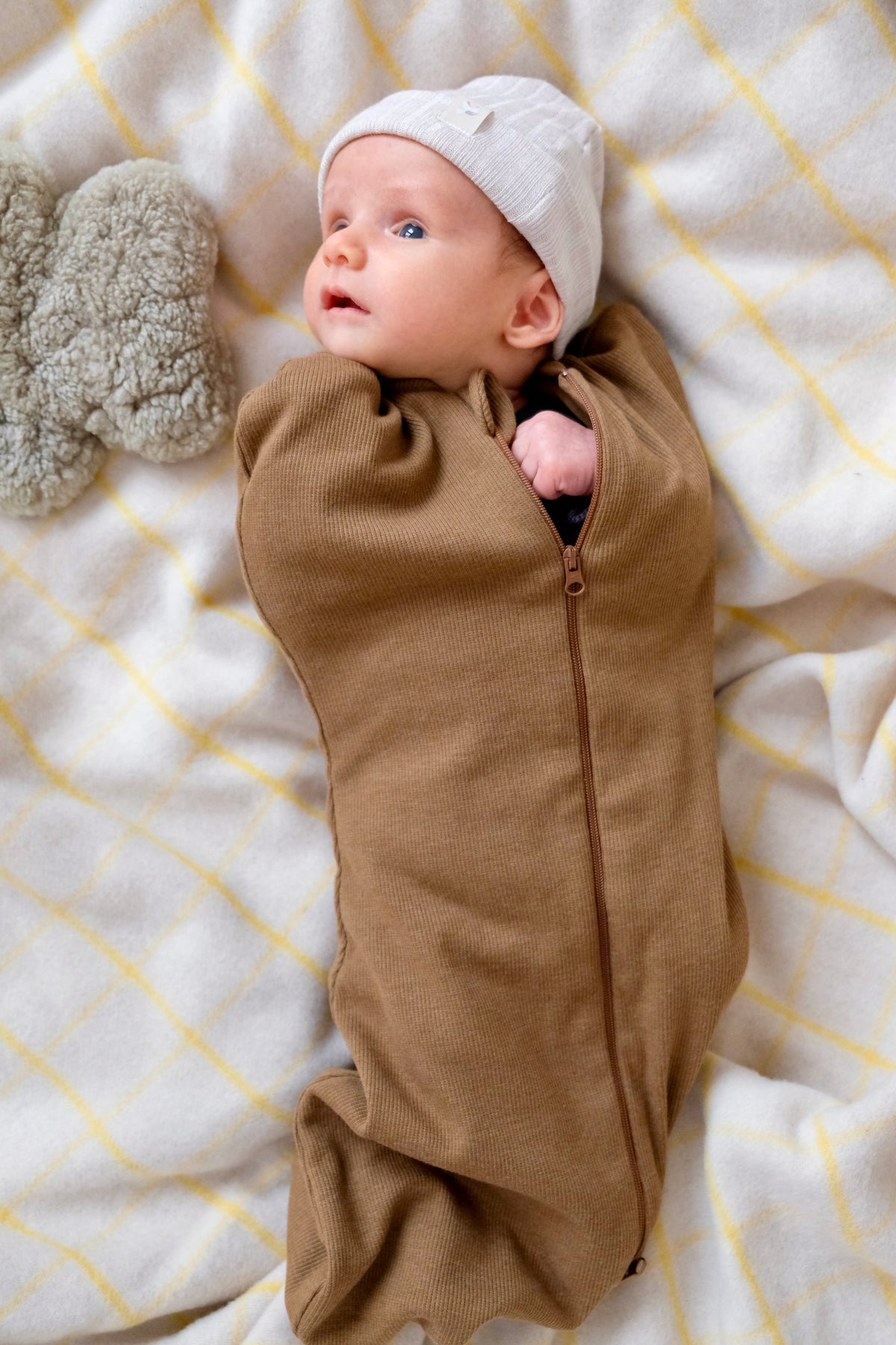 petit bébé emmailloté sur couverture et bonnet avec peluche