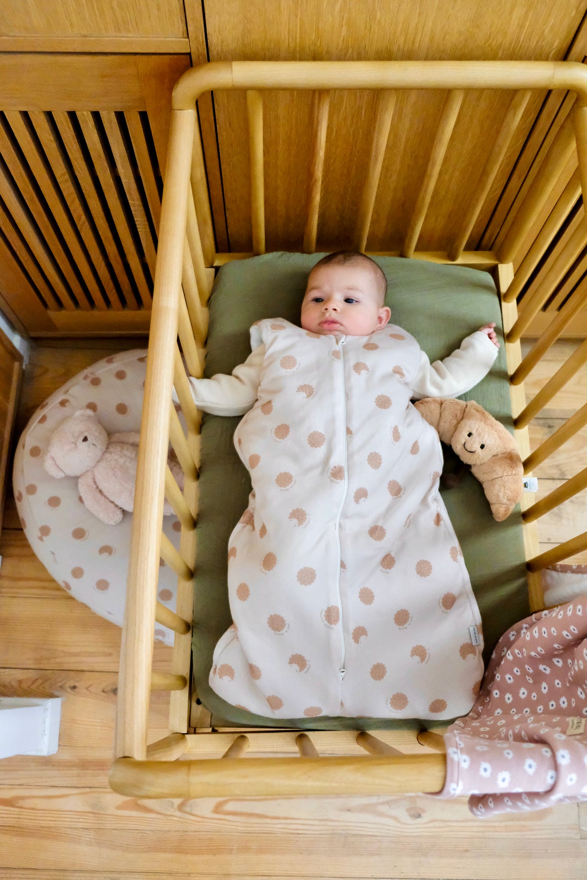 bebe dans un lit a barreau avec gigoteuse hiver cookie