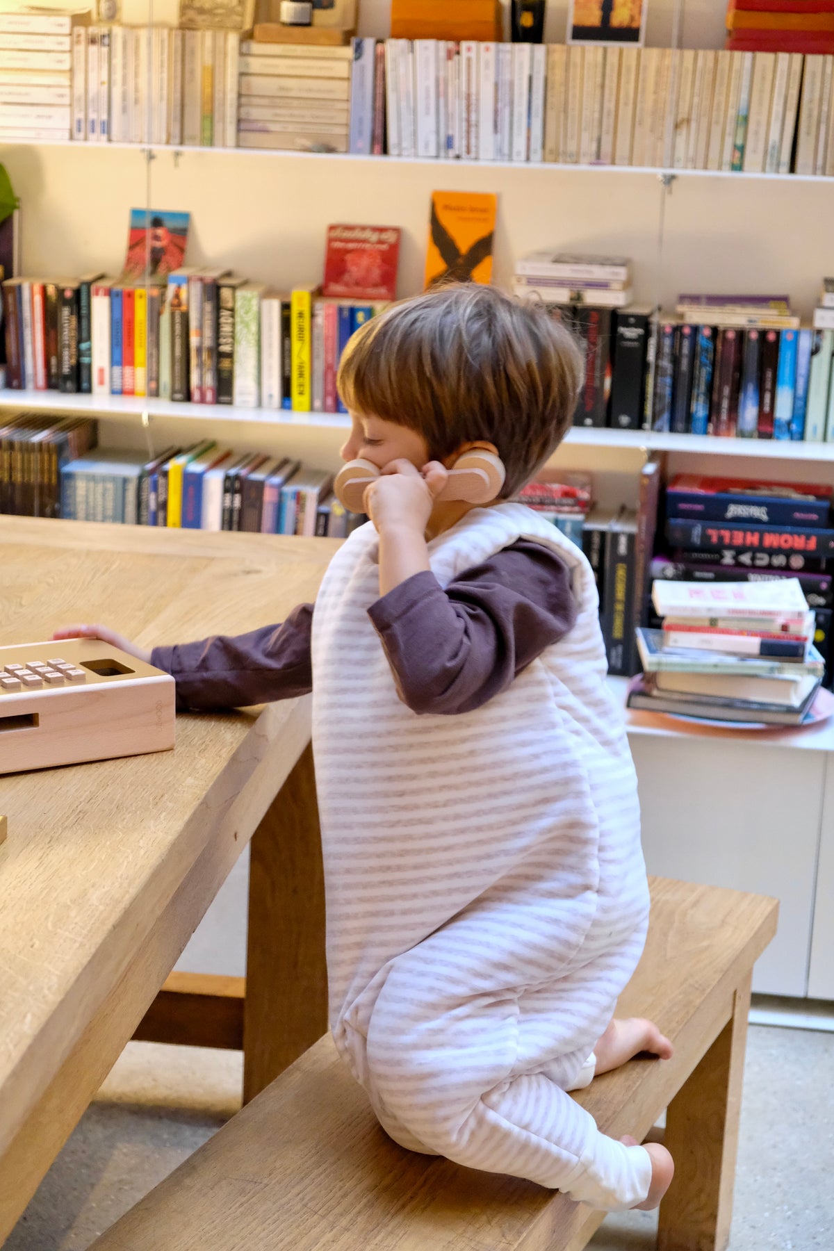 enfant téléphonant avec gigoteuse à pieds rayée latte