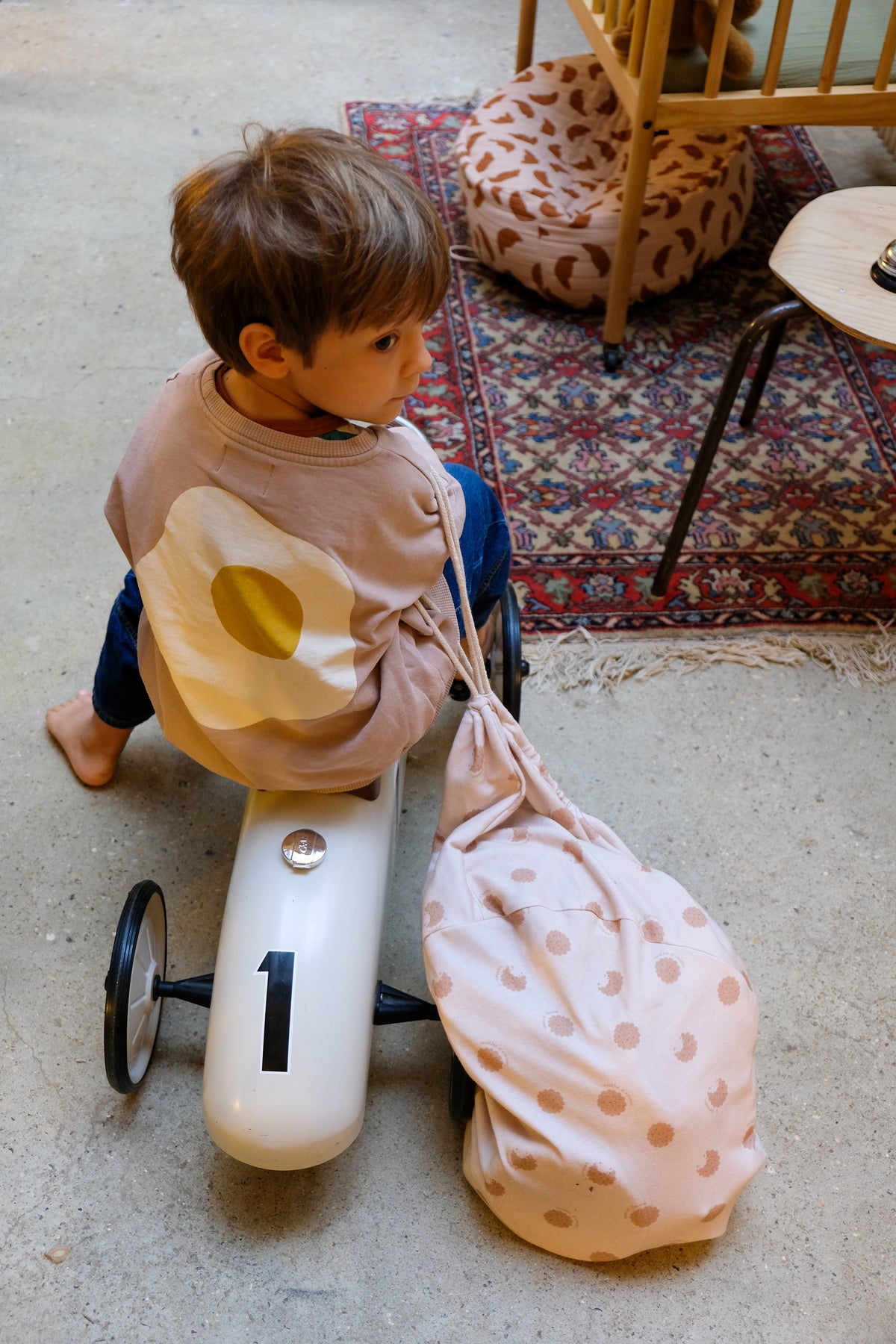 enfant sur porteur tirant un nid bag cookie