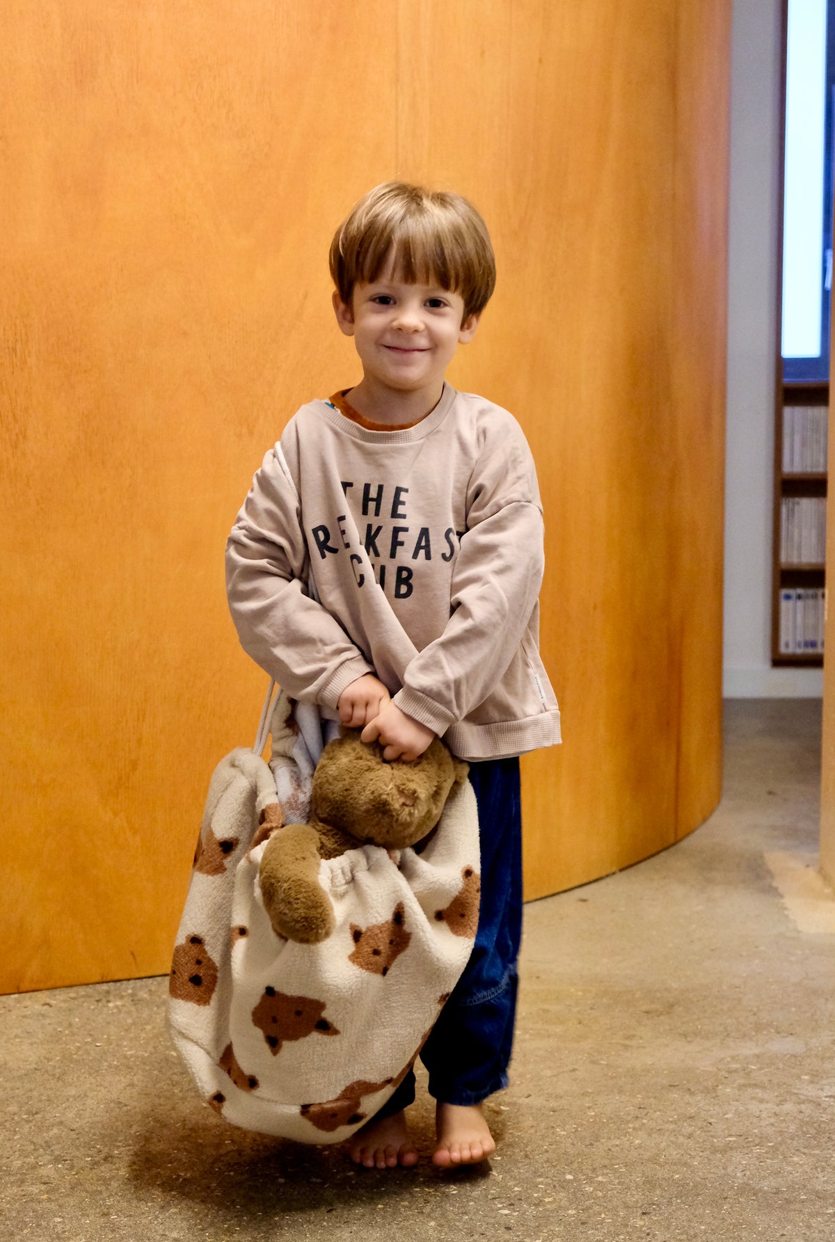 enfant portant un sac de peluche